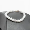 Bracelet élégant en perles d'eau douce blanches avec un fermoir doré en acier inoxydable par Ascellà Algérie.