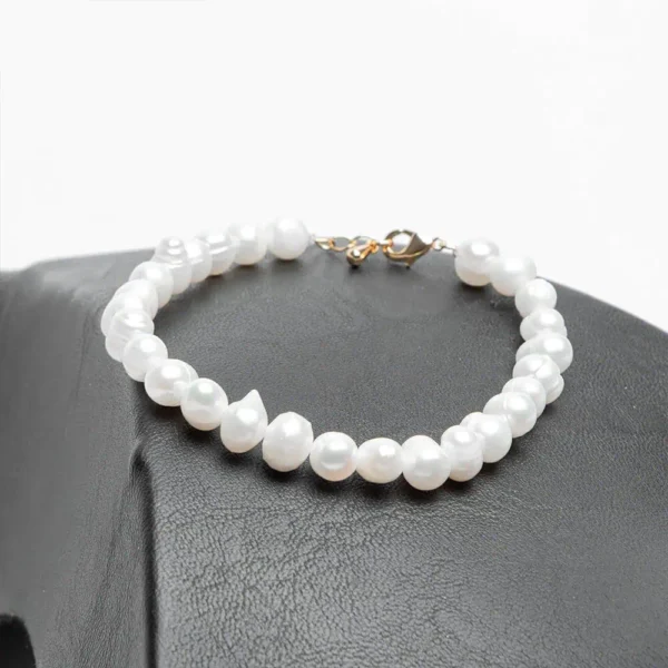 Bracelet élégant en perles d'eau douce blanches avec un fermoir doré en acier inoxydable par Ascellà Algérie.