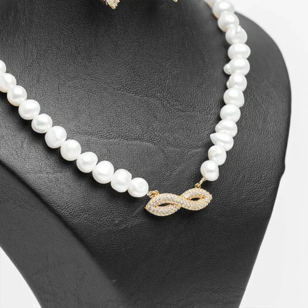 Collier parure L'infini doré perles blanches symbole infini zircons finition dorée