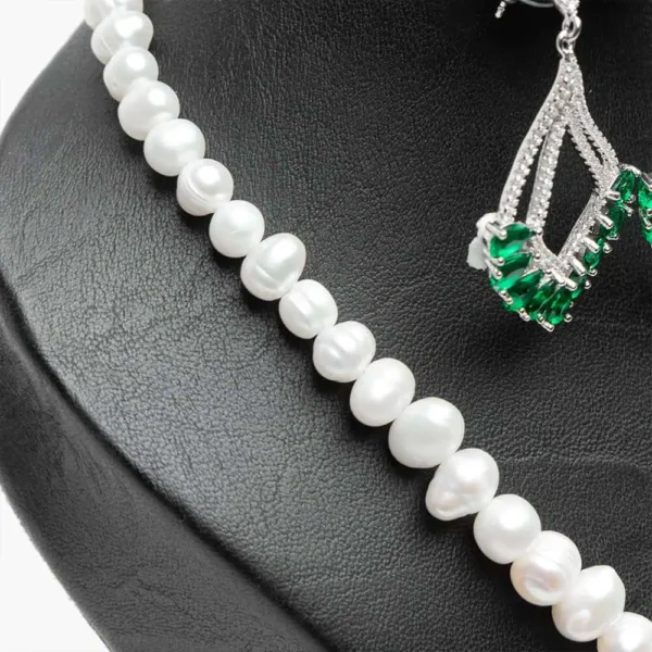 Gros plan perles d'eau douce naturelles blanches de haute qualité parure Vert émeraude